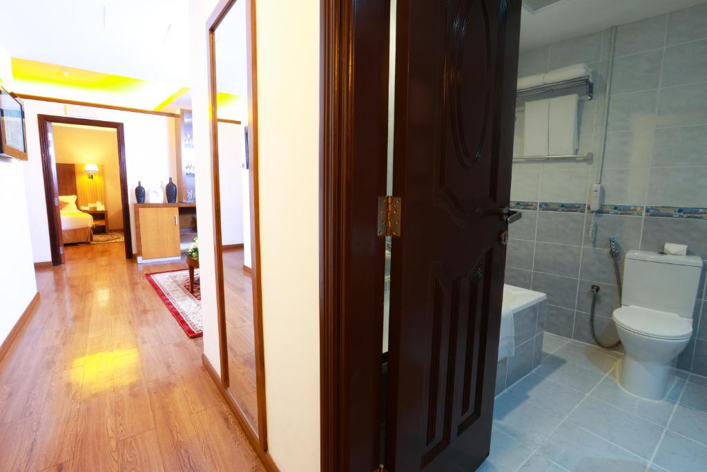 a bathroom with a toilet and a tub in a room at Fortune Pearl Hotel in Dubai
