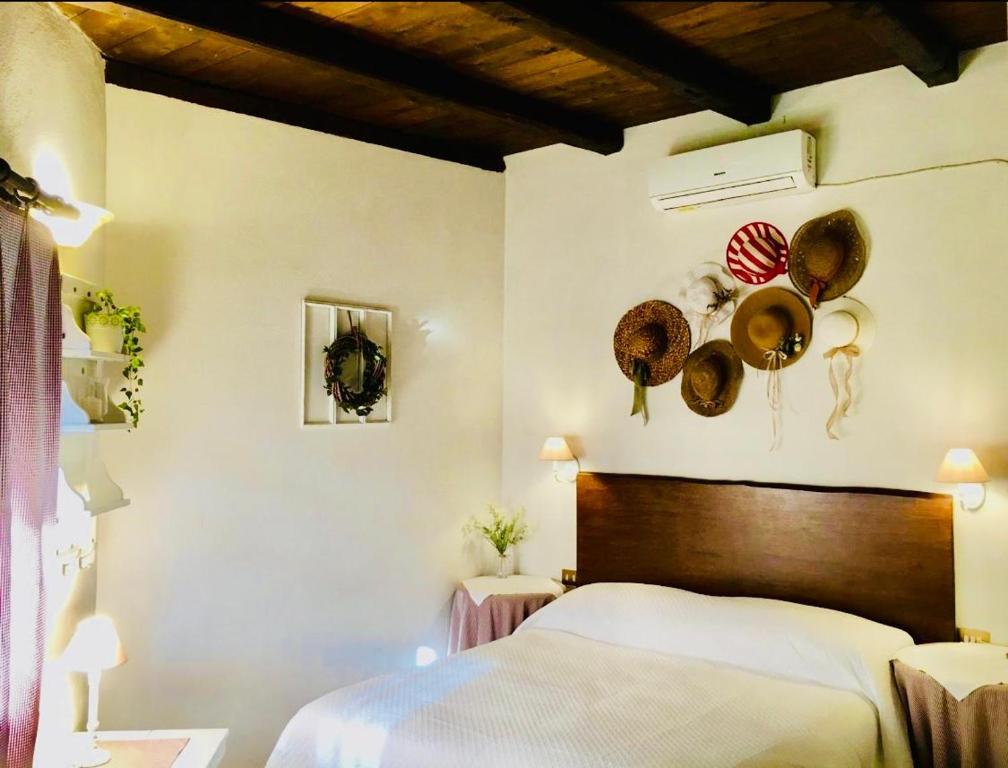 een slaapkamer met een bed met hoeden aan de muur bij country house in Ardea