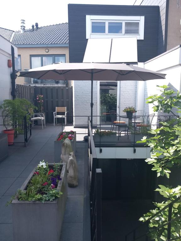 a patio with an umbrella and some plants at Touristflat Dewulf in Ghent