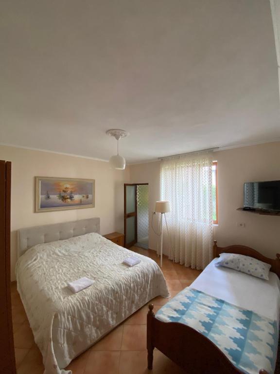 een slaapkamer met een groot bed en een raam bij Selami GuestHouse in Peshkopi