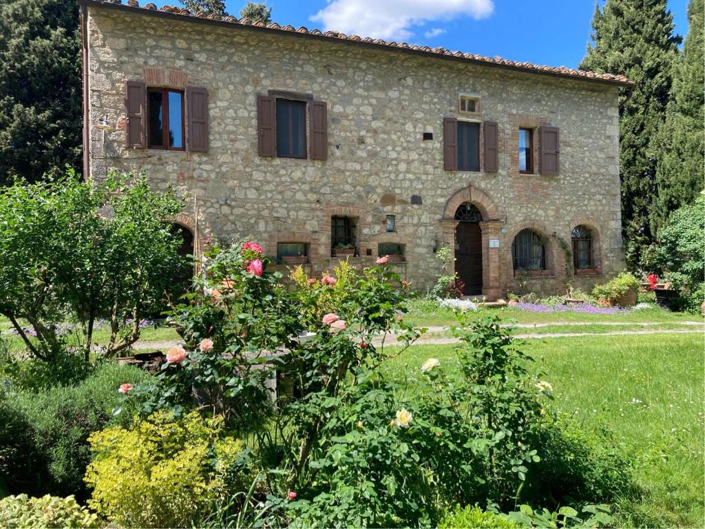 an old stone house with flowers in a garden at Agriturismo Il Caio in Cetona