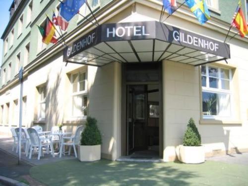 a hotel with tables and chairs outside of it at Gildenhof An den Westfalenhallen Dortmund in Dortmund