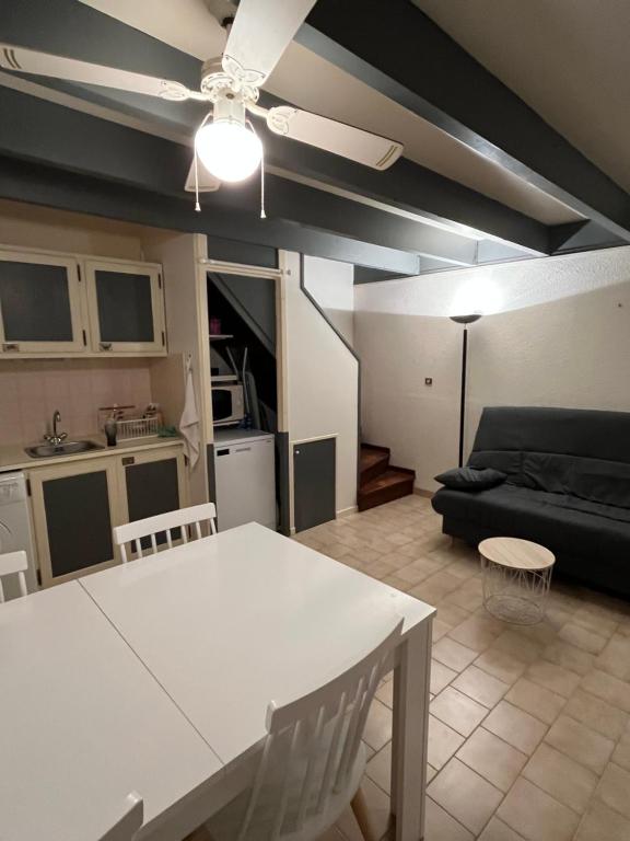 un salon avec une table blanche et un canapé dans l'établissement Maison T2 + cabine dans résidence avec piscine, à Marseillan