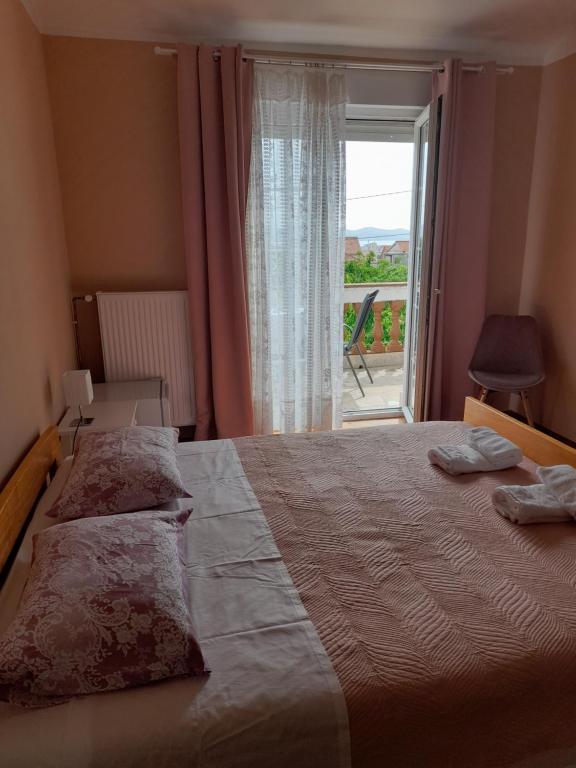 a bedroom with a bed and a window with a view at Rooms Margarita in Zadar