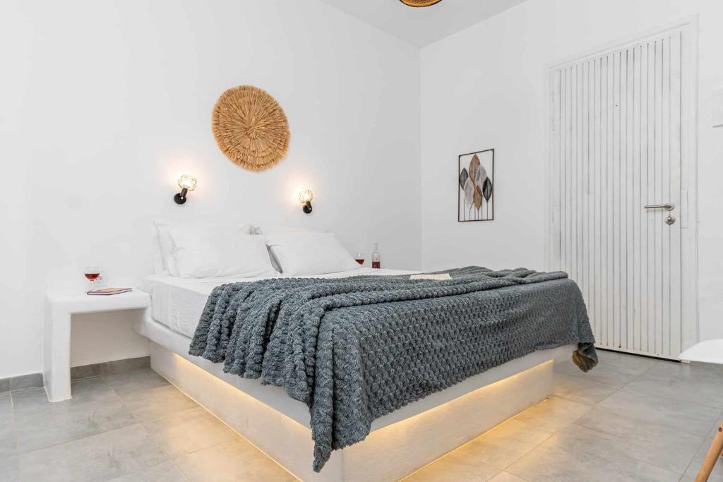 a white bedroom with a bed and a table at Naxos Beachwalk Rooms in Naxos Chora