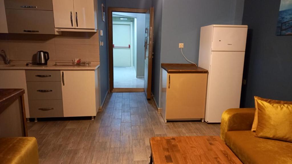 eine Küche und ein Wohnzimmer mit einem Kühlschrank und einem Sofa in der Unterkunft EVLAND CiTY SUiT in Adana