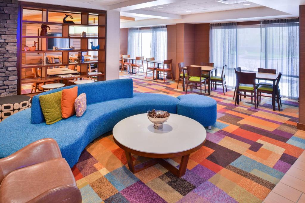 uma sala de estar com um sofá azul e uma mesa em Fairfield Inn and Suites by Marriott Rochester West/Greece em Rochester