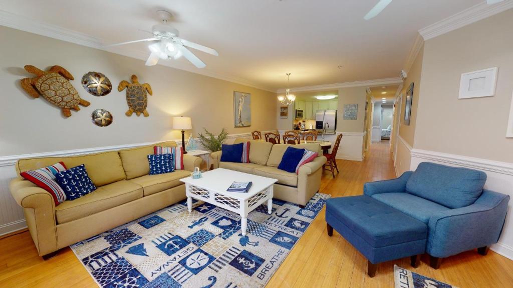 a living room with a couch and chairs and a table at Brass Rail Villas 109 by Tybee Vacation Rentals in Tybee Island