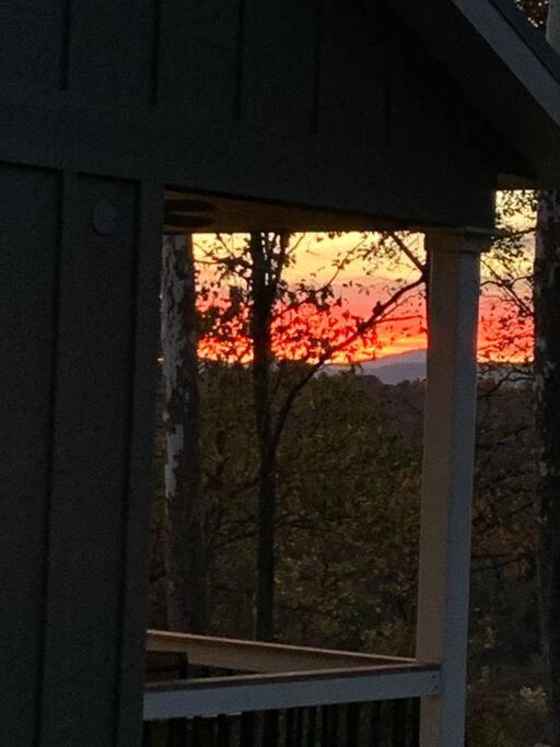 a sunset seen through a window of a house at A beautiful sunset cottage in Hendersonville