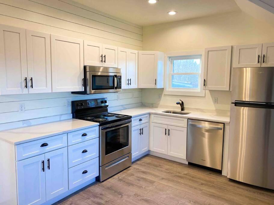a kitchen with white cabinets and stainless steel appliances at A beautiful sunset cottage in Hendersonville
