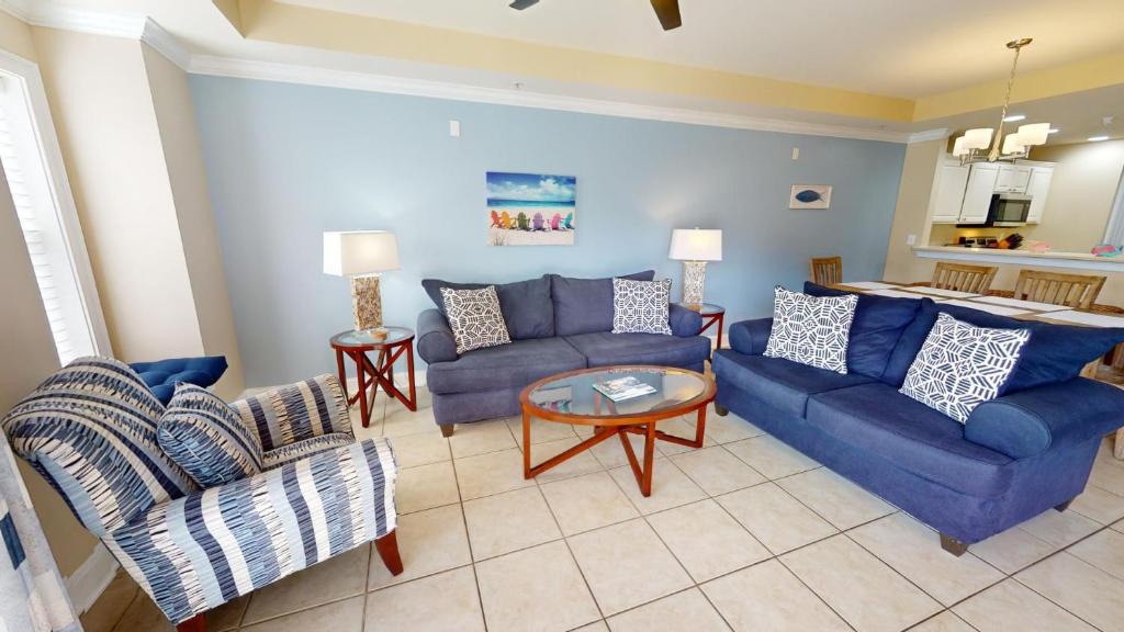 un soggiorno con due divani blu e un tavolo di Gull Reef 614 by Tybee Vacation Rentals a Tybee Island