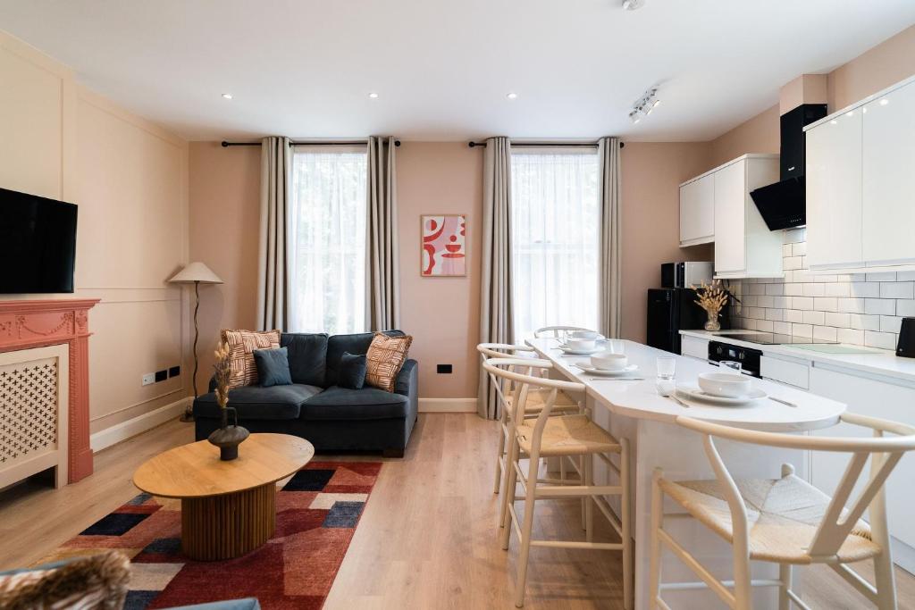 a kitchen and living room with a table and a couch at Lamington Apartments - Hammersmith in London