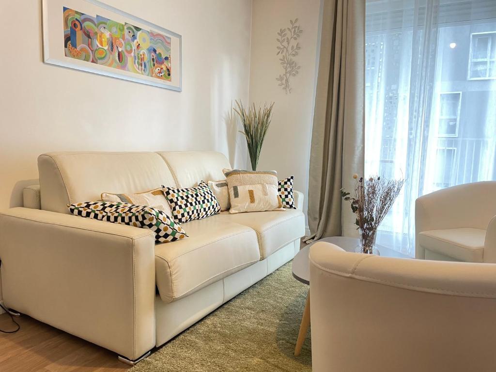 a living room with a white couch and a window at Charmant appart près du métro et aux portes de Paris in Saint-Ouen