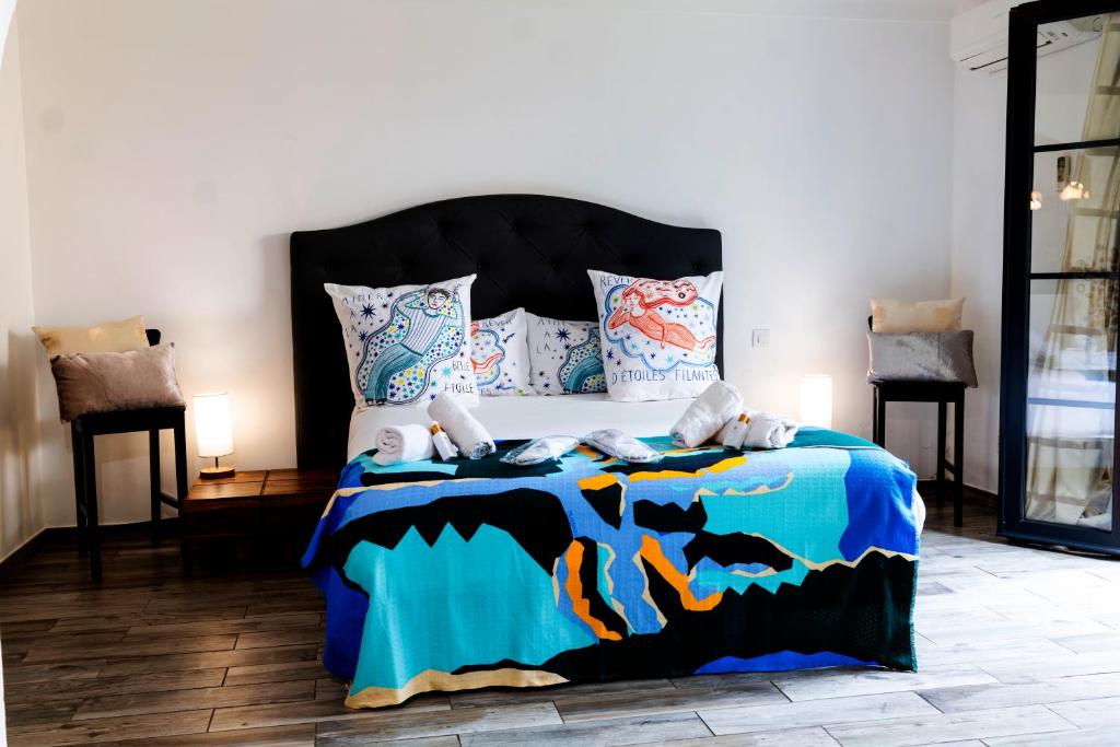 een slaapkamer met een groot bed en een blauw dekbed bij La Bravade Luxe et sérénité au cœur de Saint-Tropez Suites spacieuses avec jardin enchanteur in Saint-Tropez