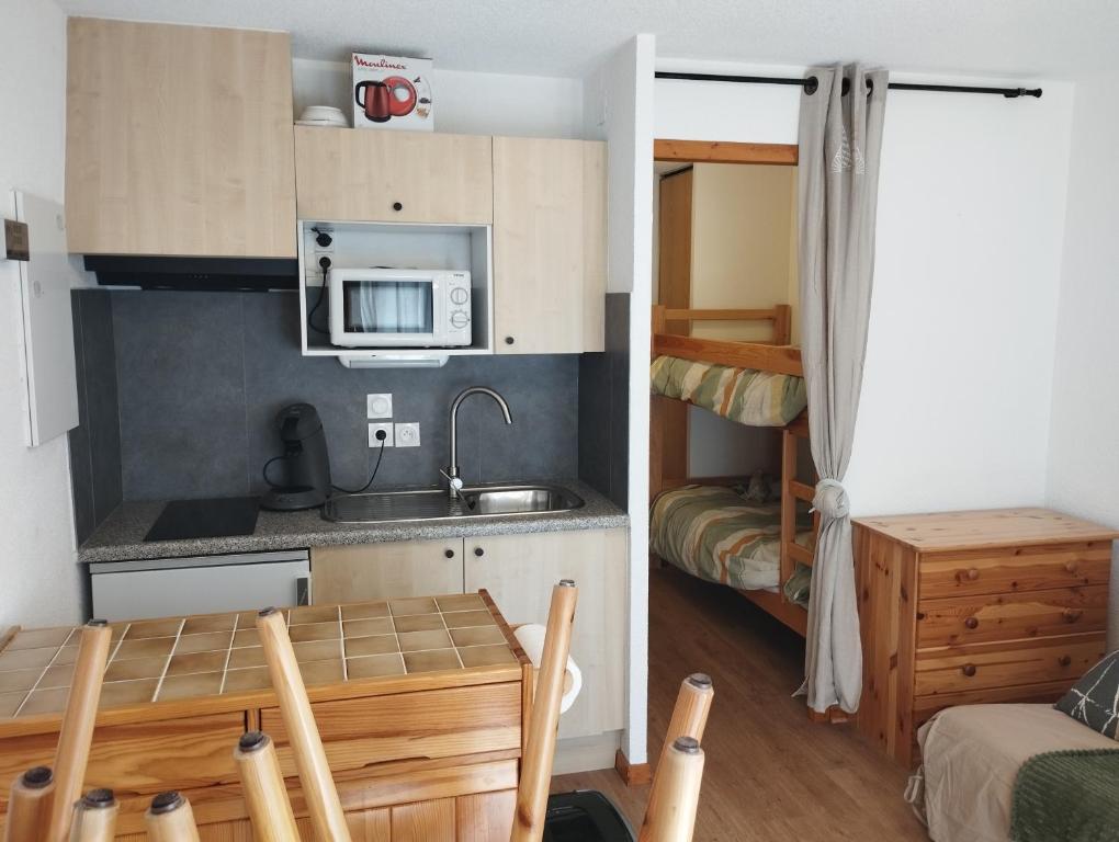a small kitchen with a sink and a microwave at Charmant studio vu sur la montagne in Le Biot