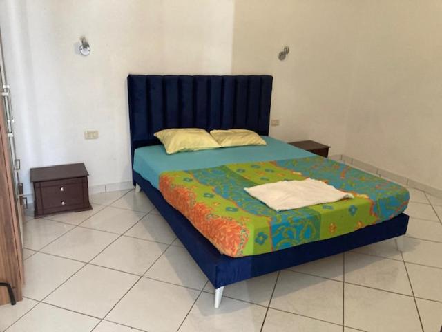 1 dormitorio con 1 cama con cabecero azul en Résidence Jlidi en Midoun