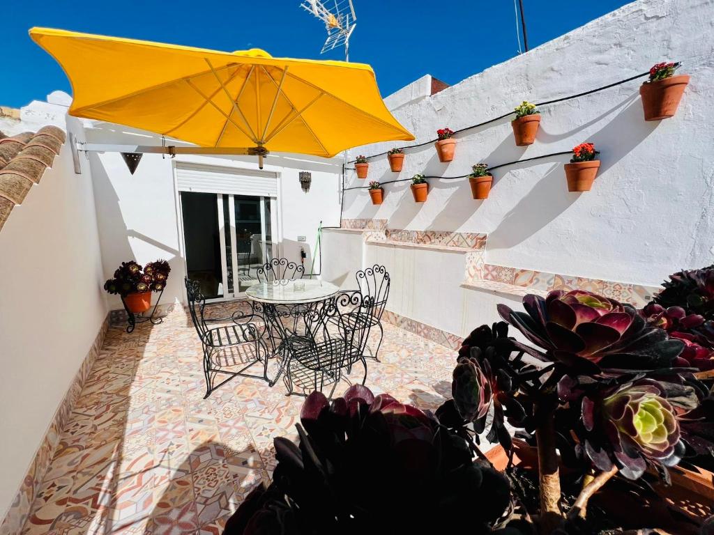 a patio with a table and chairs and an umbrella at San Fernando 33 in Córdoba