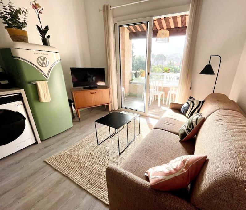 un salon avec un canapé, une table et une télévision dans l'établissement T1 bis stylé à 2 min de la mer, à Saint-Cyr-sur-Mer
