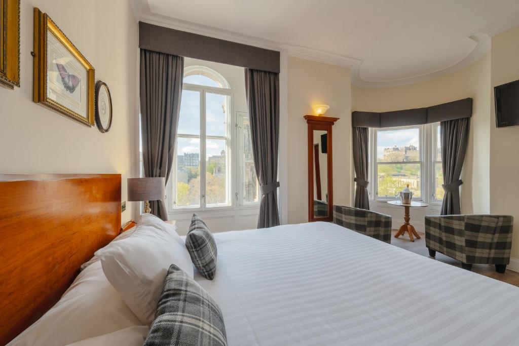ein Schlafzimmer mit einem großen Bett und einem Fenster in der Unterkunft Old Waverley Hotel in Edinburgh