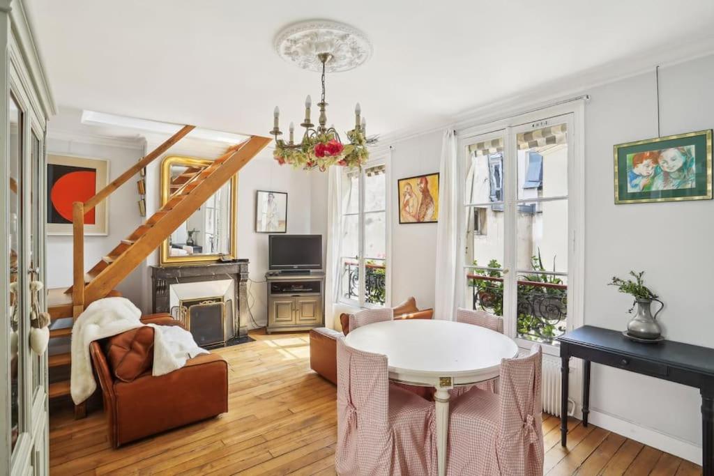 un salon avec une table et des chaises dans l'établissement L'Atelier du Peintre - Grand Triplex parisien, à Paris
