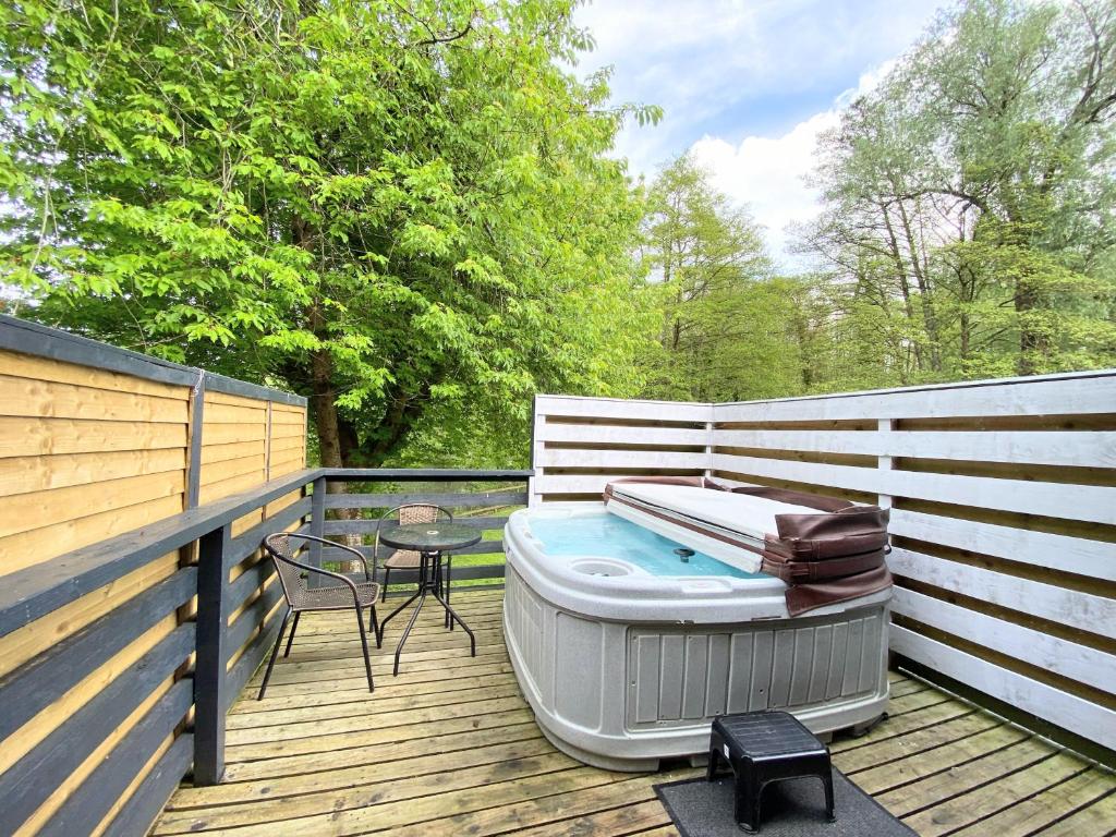 a hot tub on a deck with a table and a chair at Magpie 3 HuntersMoon-Longleat-Warminster-Bath in Warminster