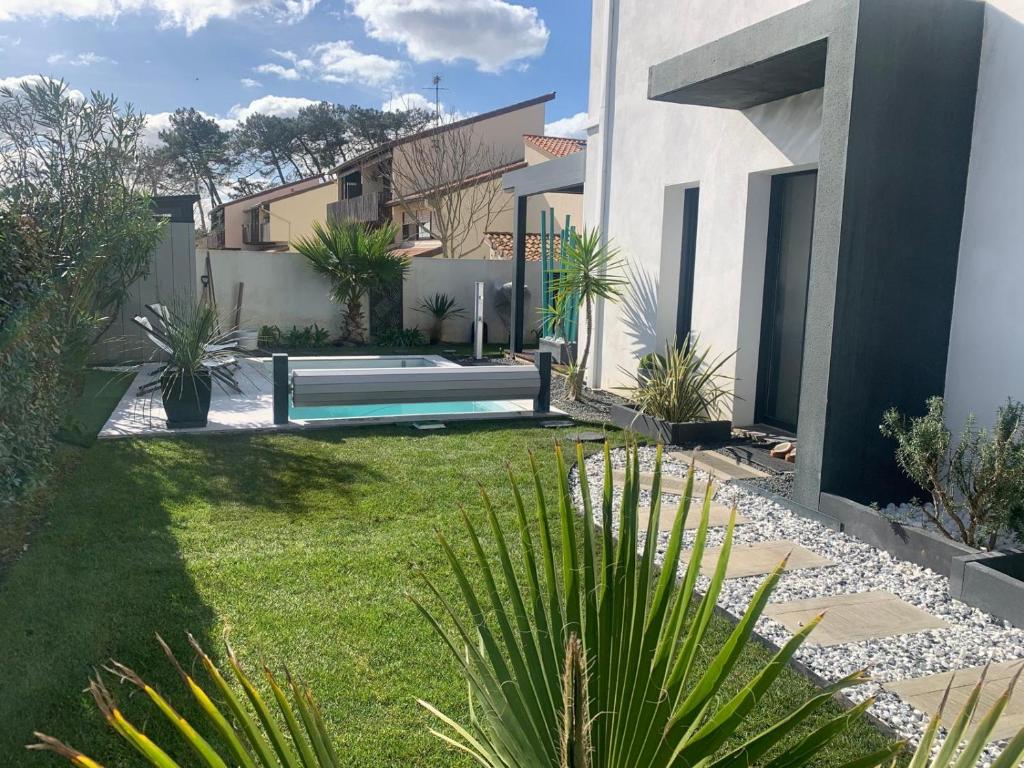 un jardin avec un banc et quelques plantes dans l'établissement Maison port et foret, à Anglet