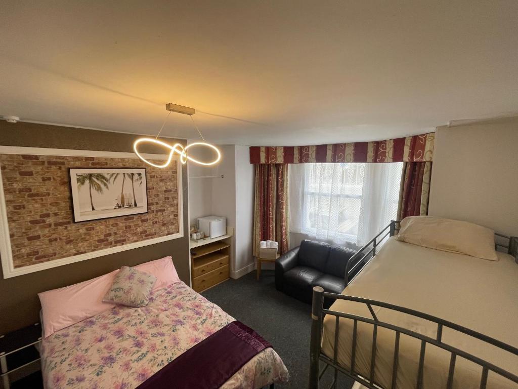 a bedroom with a bed and a chair in a room at Backpackers Blackpool - Family Friendly Hotel in Blackpool