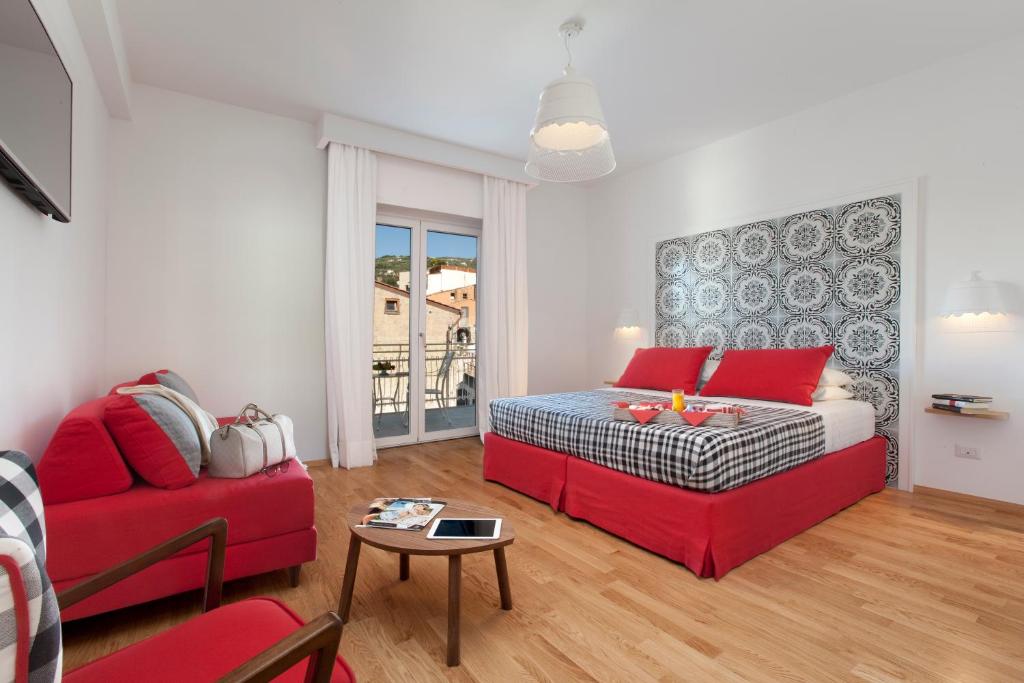 a living room with a bed and a red couch at Maison Kalea in Sorrento