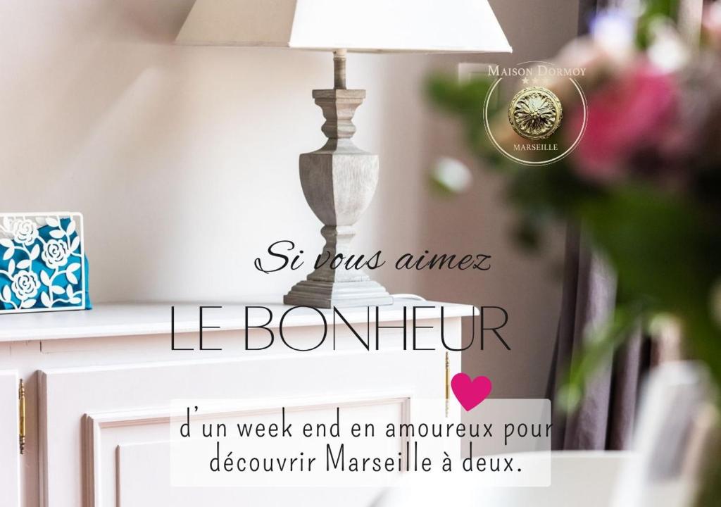 uma lâmpada sobre uma mesa com um sinal que diz lebombure em Maison Dormoy em Marselha