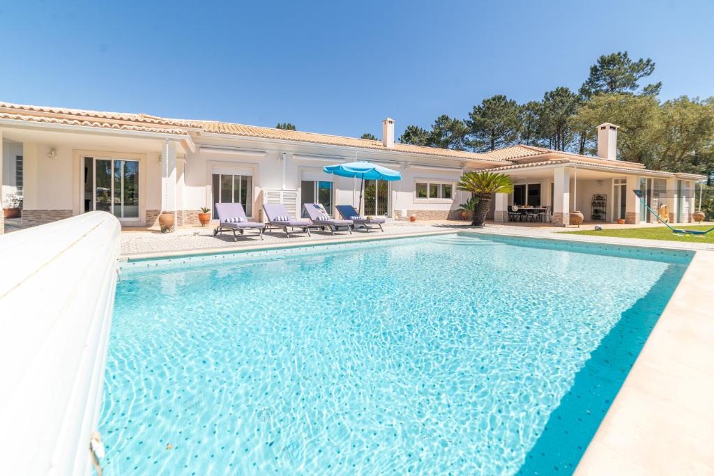 una piscina frente a una casa en Villa das Giestas en Quinta do Conde