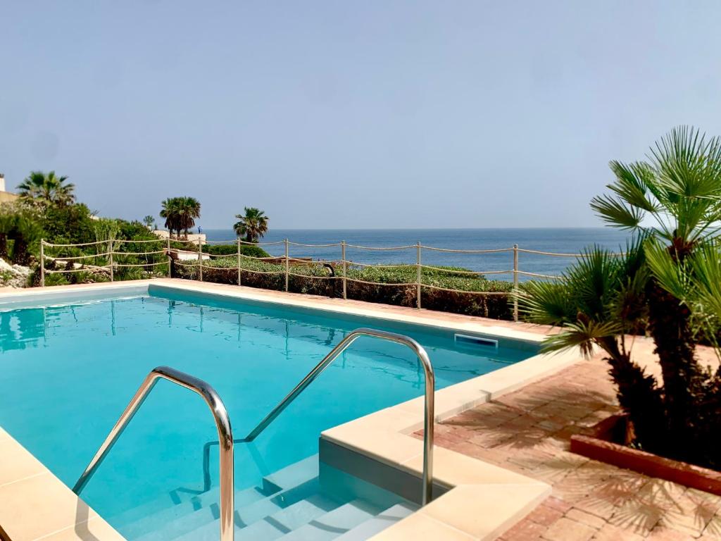 a swimming pool with a view of the ocean at Villa Luce in Siracusa