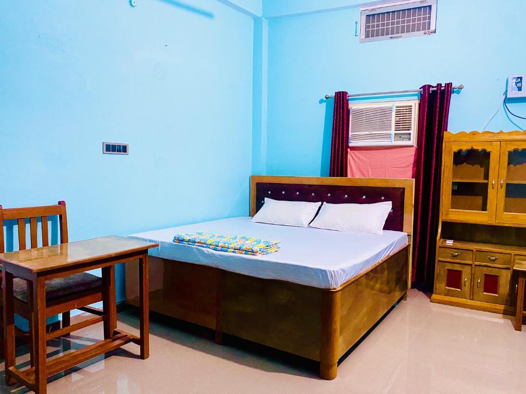 una camera con letto, tavolo e sedia di The Narayan Bhawan , ramanuj ashram ,haridas nagar ,ramkot ayodhya ji a Ayodhya