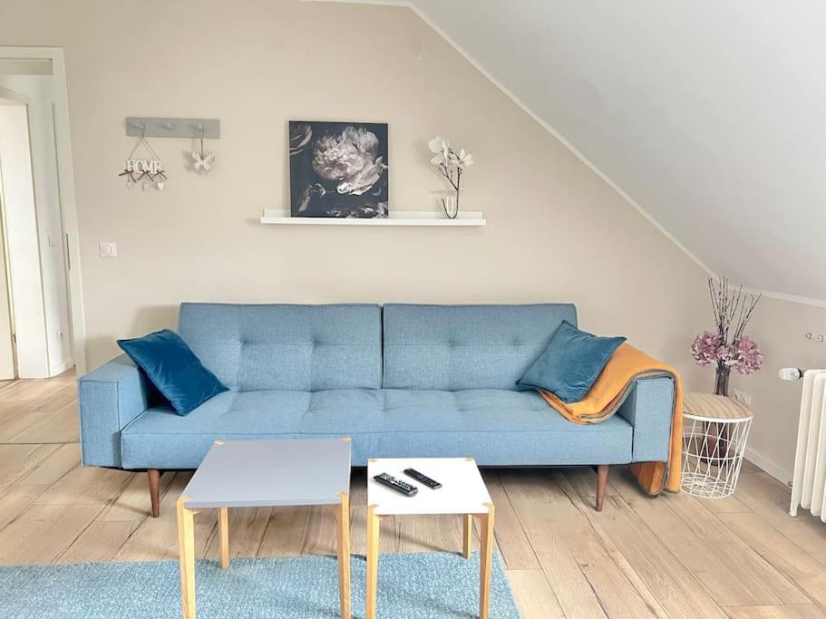 Una sala de estar con un sofá azul y una mesa. en Tolle 2 Zimmer Wohnung Nähe ICE, en Siegburg