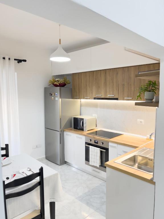 a kitchen with a stainless steel refrigerator and white cabinets at Boulevard Apartaments - Vlora in Vlorë
