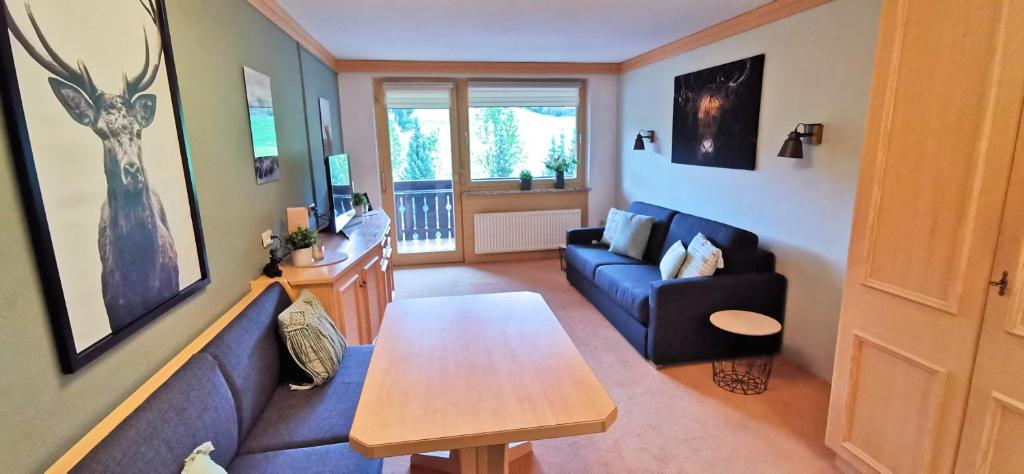 ein Wohnzimmer mit einem blauen Sofa und einem Tisch in der Unterkunft Maria Alm - komfortables Apartment Gipfelglück in Saalfelden am Steinernen Meer