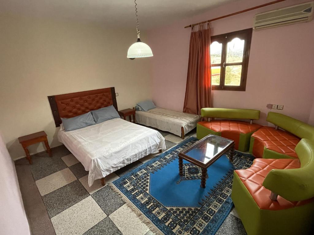 sala de estar con cama y sofá en Hotel Tanout en Azilal