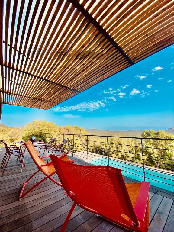 un hamac rouge sur une terrasse avec vue dans l'établissement Poggio Raseddu, à Monacia-dʼAullène