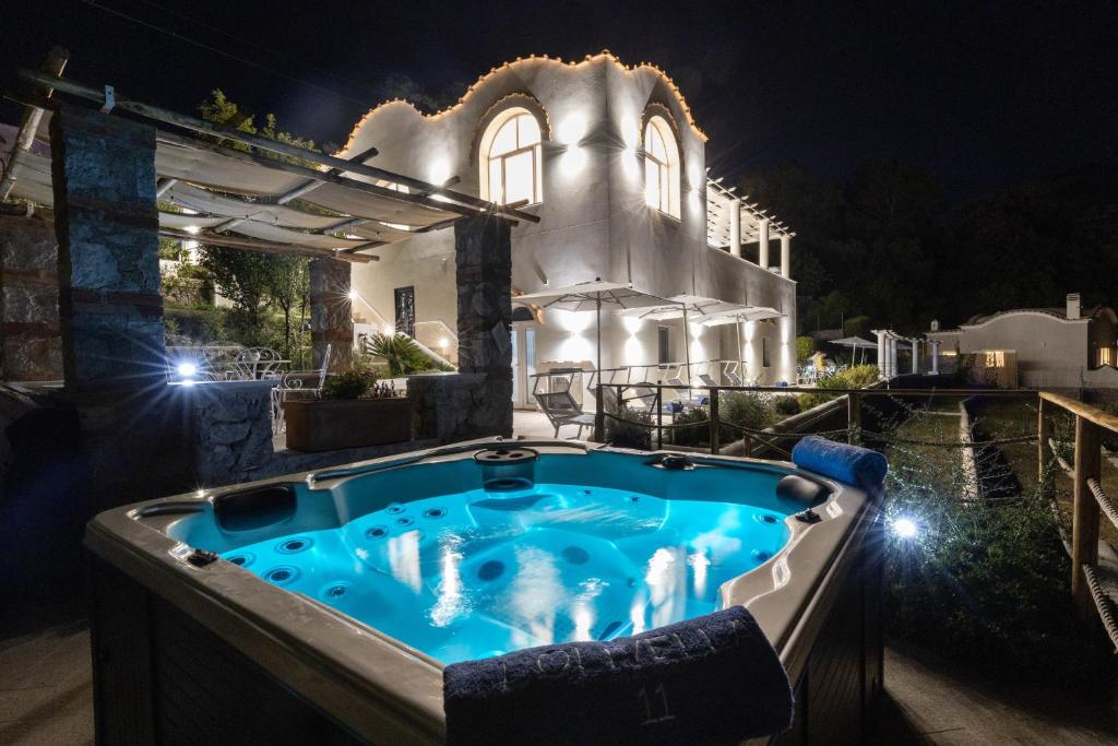 a jacuzzi tub in front of a house at night at AMORE RENTALS - Villa Olivella in Anacapri
