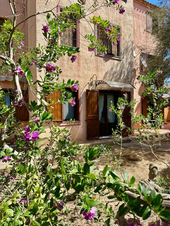 an old building with flowers in front of it at Moresca Apartment by Jennas in Àrbatax