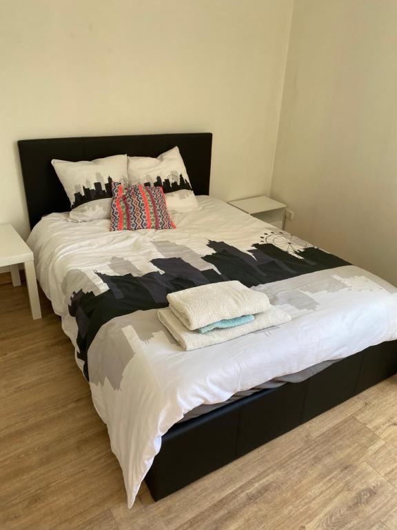 un grand lit avec deux oreillers dessus dans l'établissement Haut de jardin dans une maison, à Dijon