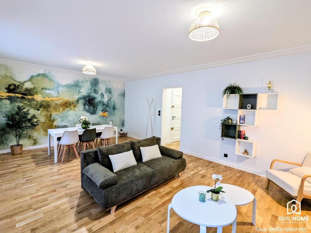 a living room with a couch and a table at L'Impressionniste - Spacieux - Lumineux - Central in Orléans