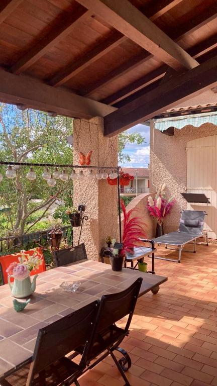 un patio avec une table et des chaises sur un patio dans l'établissement Chambre au calme, à Lagarrigue