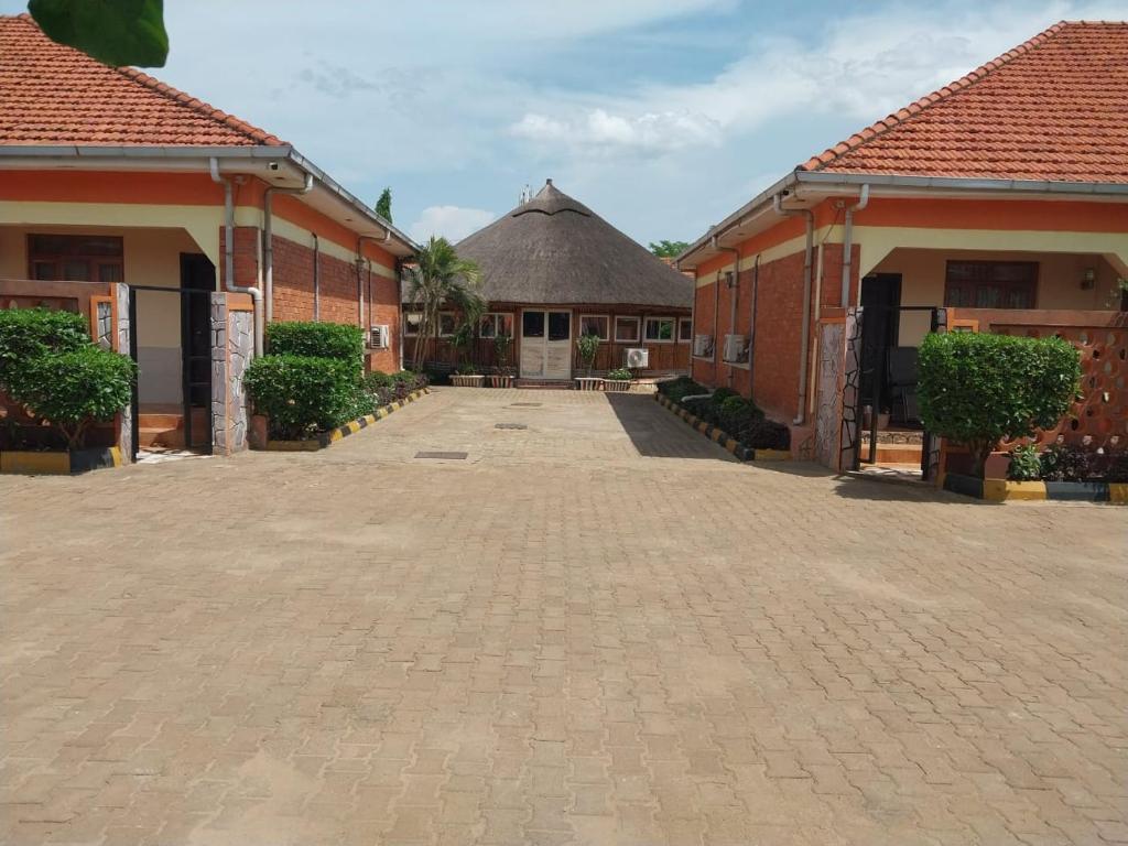 um pátio com dois edifícios de tijolos com telhado de palha em Tulba Hotel and Residences em Juba