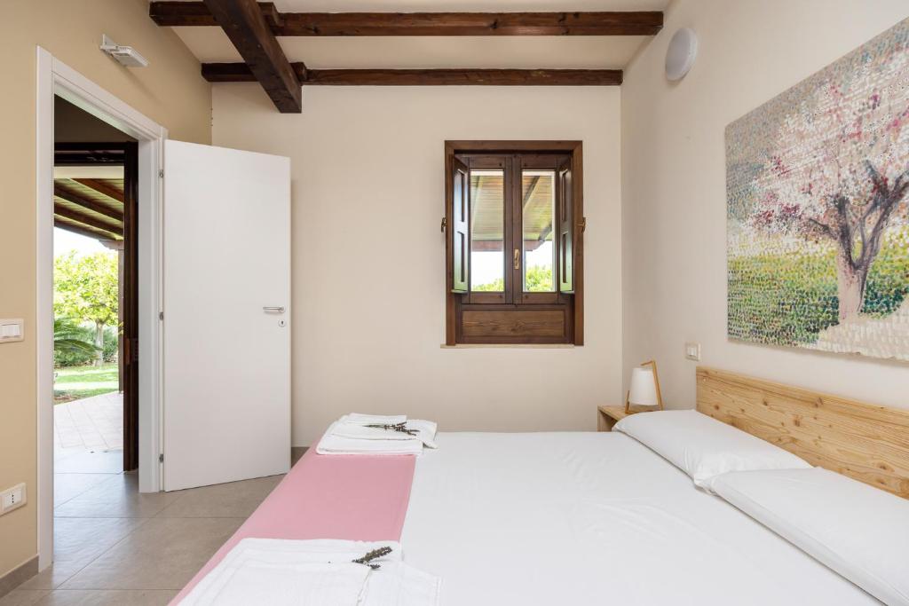 two beds in a bedroom with a painting on the wall at Fiore di Vendicari B&B - Sicilian Charme, Lemon Grove and Sea in Noto