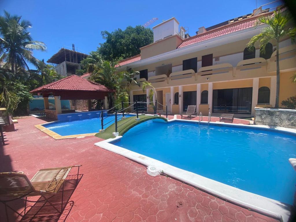 una grande piscina di fronte a una casa di Vista Caribe Playa a Playa del Carmen