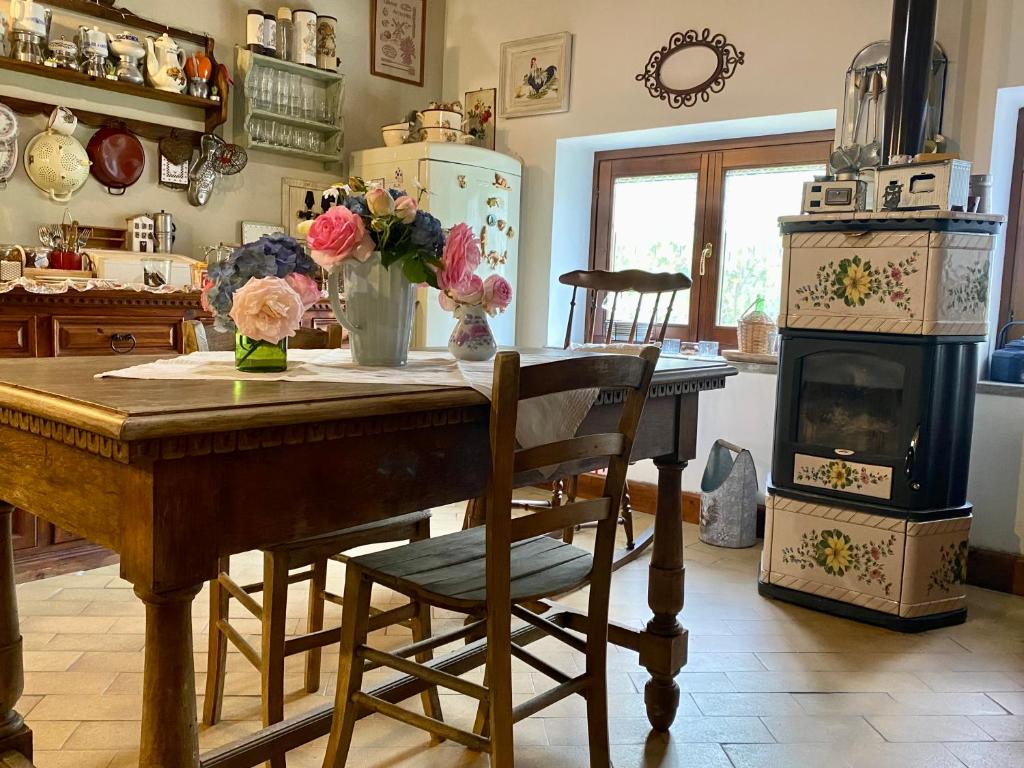 a kitchen with a table with flowers and a stove at La Locanda Del Tevere in Fiano Romano