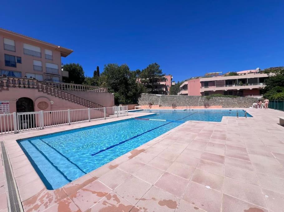 - une piscine à côté d'un bâtiment dans l'établissement Studio, piscine, parking, à Saint-Tropez