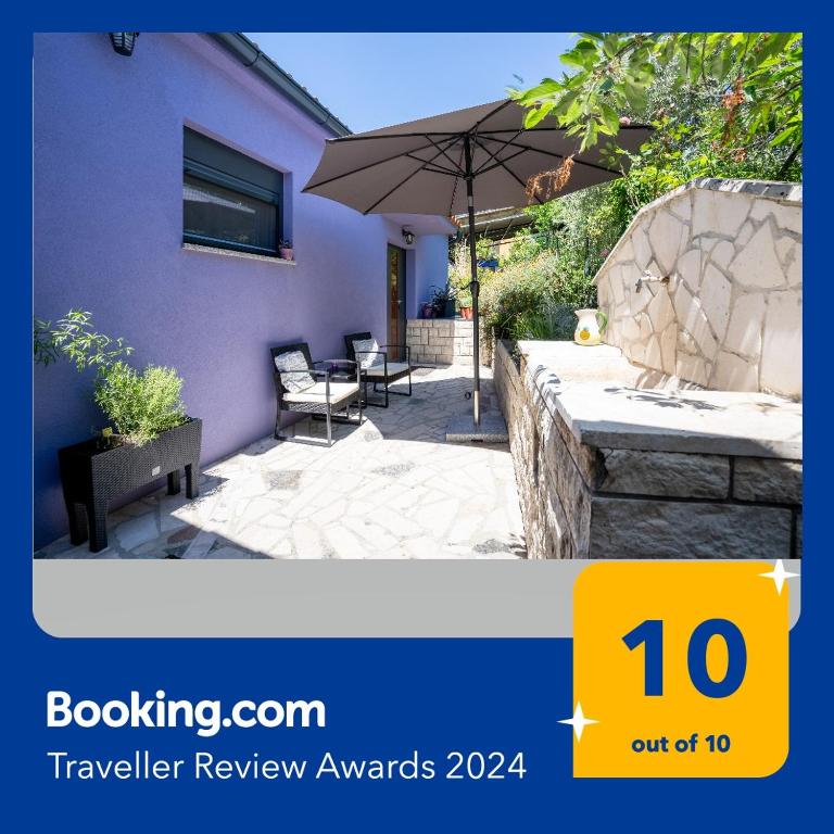 a picture of a patio with an umbrella at Apartments Villa Rosa in Rovinj