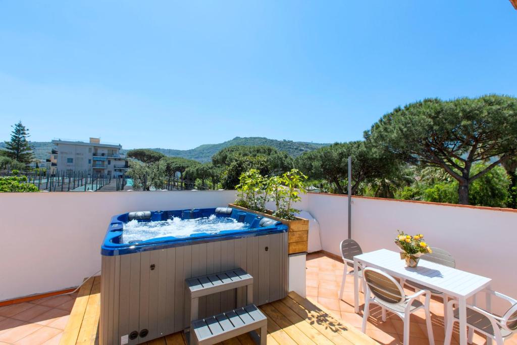 - un bain à remous sur un balcon avec une table et des chaises dans l'établissement YourHome - Jolly Pini Apartment, à Sant'Agnello