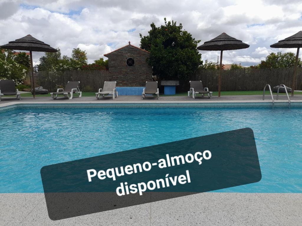un cartel junto a una piscina con sillas y sombrillas en Terras de Monsaraz, en Reguengos de Monsaraz